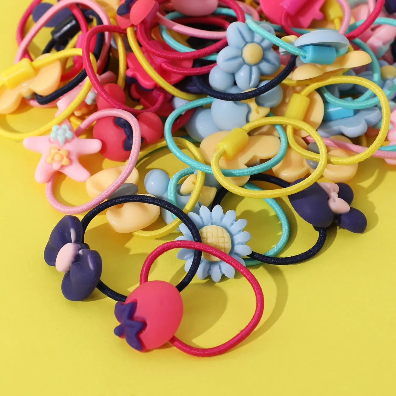 Paquete de 50 cintas para el pelo elásticas multicolores con decoración de dibujos animados y lazo floral para niñas Bloque de color big image 1