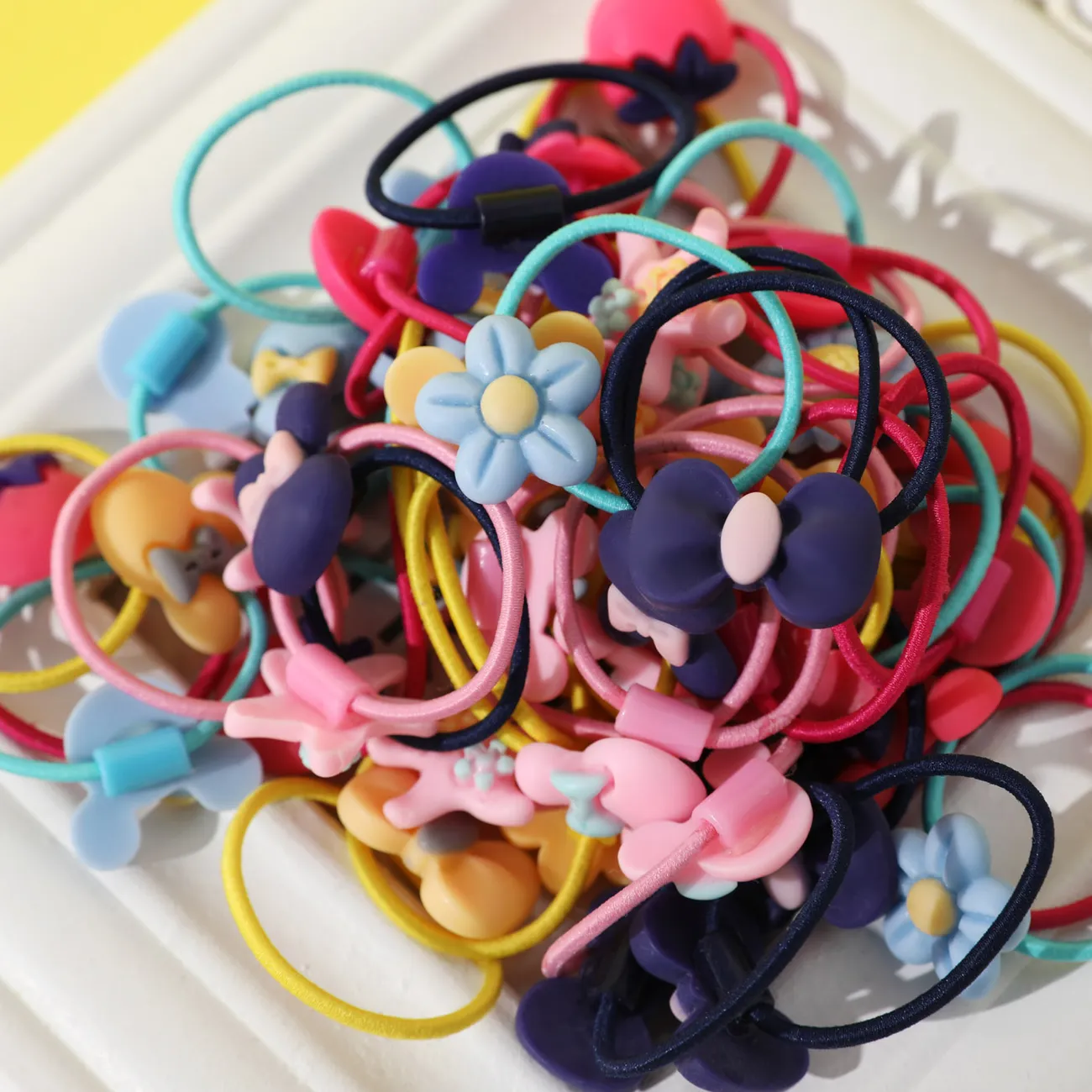 Paquete de 50 cintas para el pelo elásticas multicolores con decoración de dibujos animados y lazo floral para niñas Bloque de color big image 1