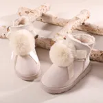 طفل صغير وأطفال بومبوم ديكور أحذية الثلج أبيض
